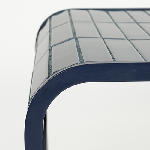 Doska zdobená keramickými dlaždicami vytvára jedinečnú mozaikovú textúru